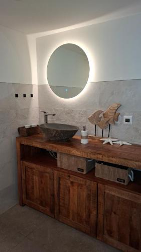 a bathroom with a sink and a mirror on a counter at Bungalow am Wald in Coswig