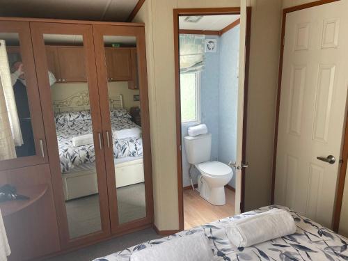 a bathroom with a toilet and a bed in a room at 38 the pines in Newton on the Moor