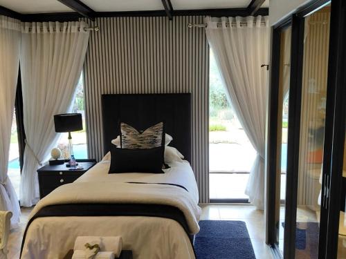 a bedroom with a large bed and a large window at Kathuhari Guesthouse in Kathu