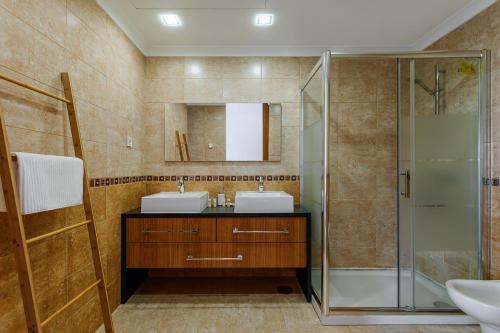 a bathroom with two sinks and a shower at Ocean Village Eden in Troia