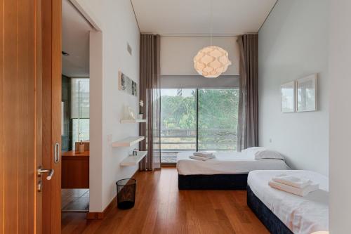 a bedroom with two beds and a large window at Ocean Village Eden in Troia