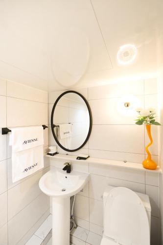 ein weißes Badezimmer mit Spiegel und Waschbecken in der Unterkunft AvIENNE 홍대 명동 이태원 DDP KSPO 경북궁 롯데월드 성수 in Seoul