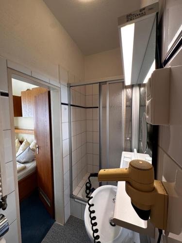 a small bathroom with a toilet and a shower at Hotel Haus Margarete am Meer in Norderney