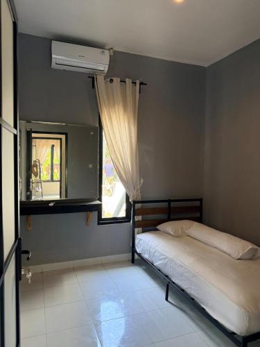a bedroom with a bed and a window at Uma Pirates Lombok in Mataram