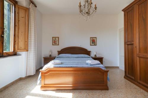 a bedroom with a wooden bed and a chandelier at Casa Natalina in Montecatini Terme