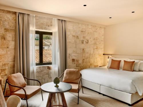 a bedroom with a bed and a table and chairs at Mangia's Costa Ragusa Borgo - New Opening in Scoglitti