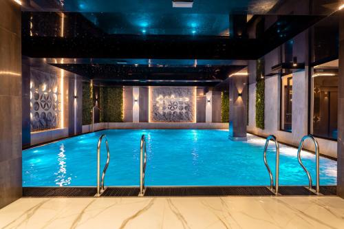 a large swimming pool with blue water in a building at Góralski Resort Family & SPA in Białka Tatrzańska