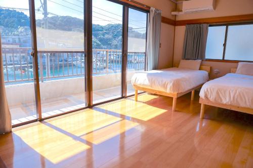 a room with two beds and a large window at Island Base Shimami in Nobeoka