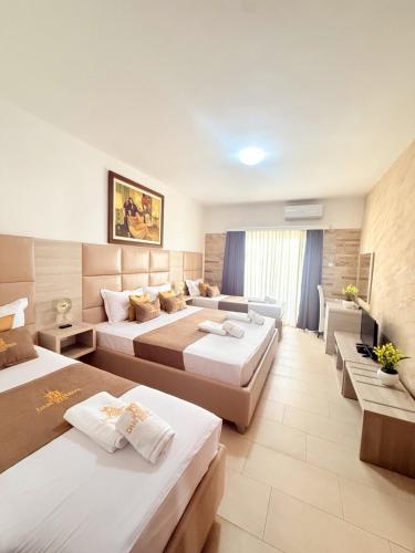 a hotel room with three beds and a couch at Hotel Dabi Imperial in Donji Štoj