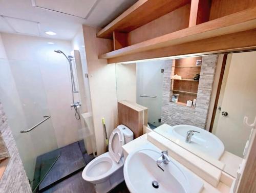 a bathroom with a toilet and a sink at Cozy Minimal 1BR CMBD Pool Long Stay Friendly in Phra Khanong