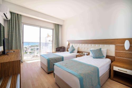 a hotel room with two beds and a balcony at Blue Diamond Alya Hotel in Alanya