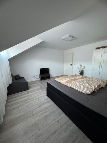 a bedroom with a large bed and a couch at Monteurzimmer Wohnung in Dillingen an der Saar