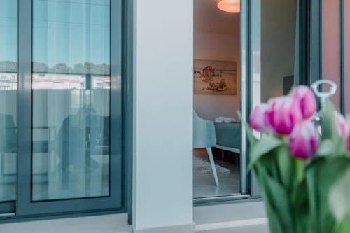 a vase of pink tulips in front of a window at Apartment - Casa Andres in Salir de Porto