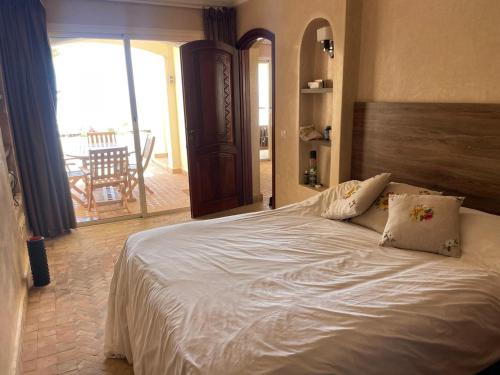a large white bed in a bedroom with a balcony at Tigert agadir in Agadir