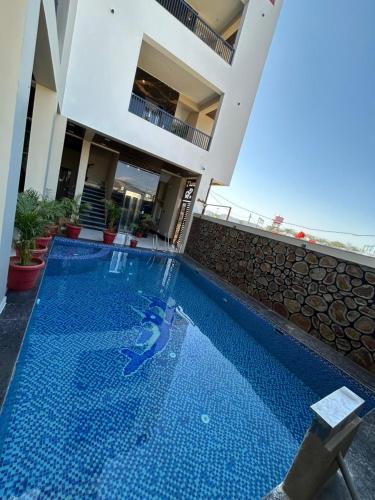 a large swimming pool in front of a house at Hotel Pushkar Pulse in Pushkar