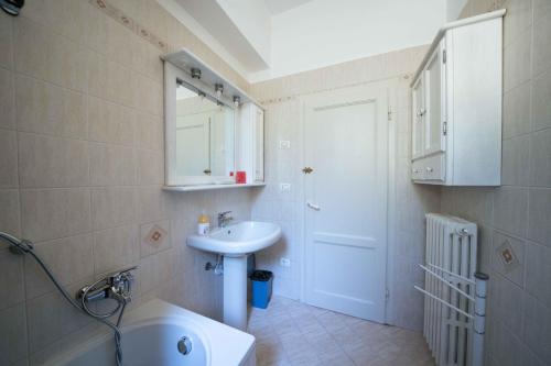 a bathroom with a sink and a toilet and a mirror at Casa Natalina in Montecatini Terme