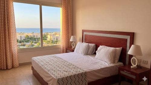 a bedroom with a bed and a large window at شاليه 2 غرفه in Marsa Alam