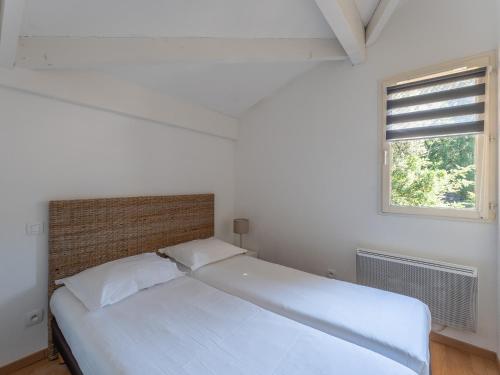 a white bed in a room with a window at Vacancéole - Les Rives du Lac in Lacanau