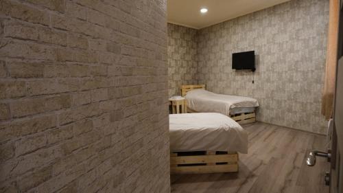a bedroom with two beds and a brick wall at Dilichella Resort in Dilijan