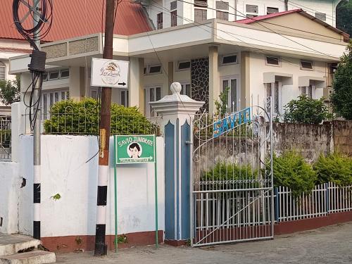 a house with a gate and a sign in front of it at LeeZaiah in Shillong
