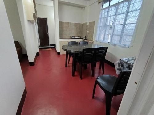 a room with a table and chairs and a red floor at LeeZaiah in Shillong