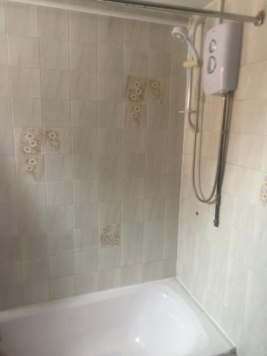 a bathroom with a shower with a white tub at A Spacious Odyssey in Dagenham