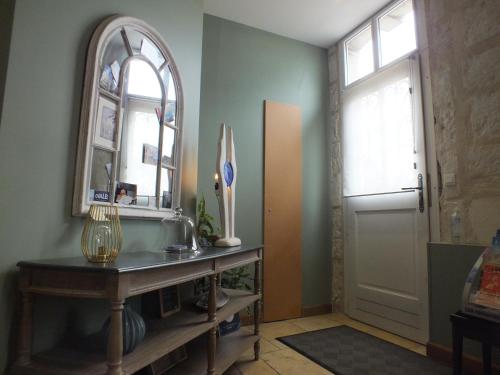 a hallway with a mirror and a table and a door at A la Fleur de Lys in Langeais