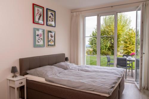 a bedroom with a bed and a large window at Terrasse im Ammergau - Bad Kohlgrub in Bad Kohlgrub