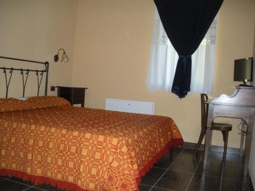 a bedroom with a bed and a desk and a window at Podere Caselina b&b in Camugnano