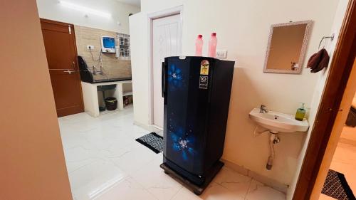 a black refrigerator in a bathroom with a sink at Boutique Bungalow 458 in Secunderabad