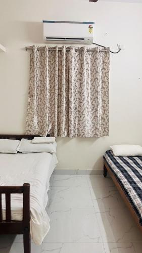 a room with two beds and a curtain at Boutique Bungalow 458 in Secunderabad