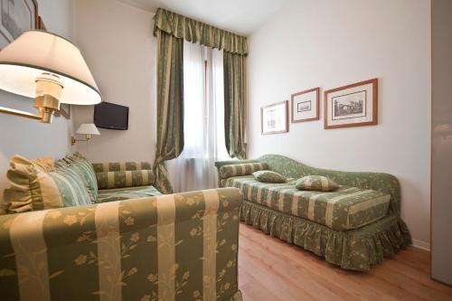 a living room with a couch and a chair at Hotel Italia in Siena