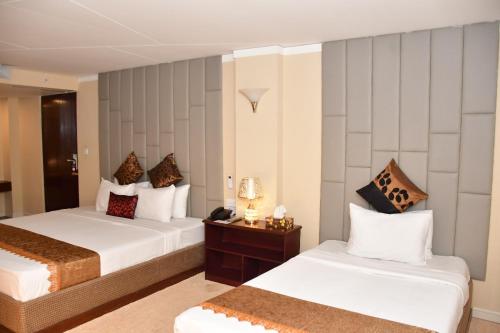 a hotel room with two beds and a table at The Green Shadow Business Hotel in Chittagong