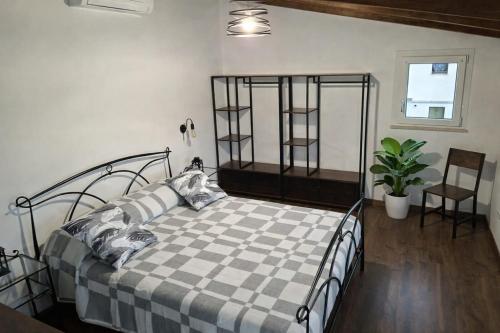 a bedroom with a black bed with a checkered blanket at Nazem Holiday in Comunanza