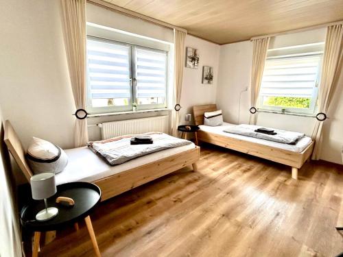 two beds in a room with two windows at Gästehaus Trockau in Pegnitz