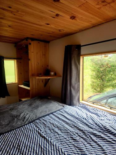 a bedroom with a bed and a large window at Cosy camping in Crots