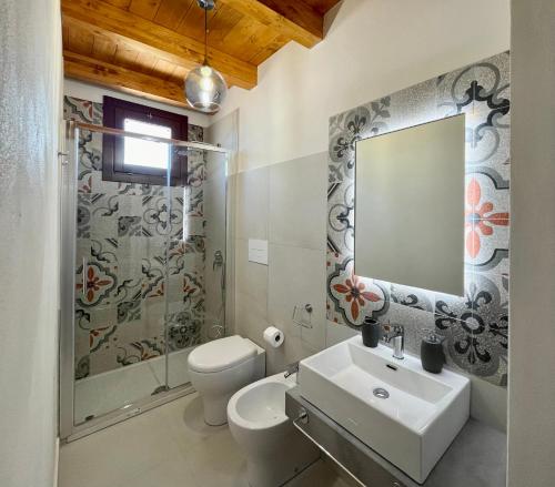 a bathroom with a sink and a toilet and a mirror at Asmara 10 in Trapani
