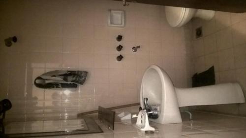 a bathroom with a sink and a tiled wall at Arco Iris in Miramar