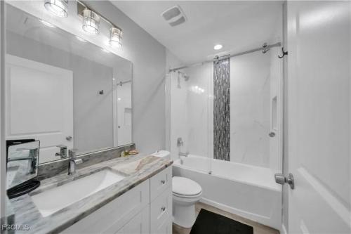 a bathroom with a tub and a sink and a toilet at Southwest Florida Paradise in Cape Coral