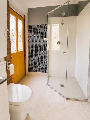 a bathroom with a toilet and a glass shower at Garden Studio with Private Patio in Wentworth Falls