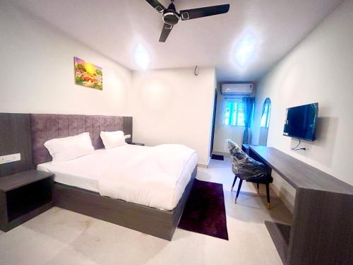 a bedroom with a bed and a desk and a television at Hotel Vira in Cuttack