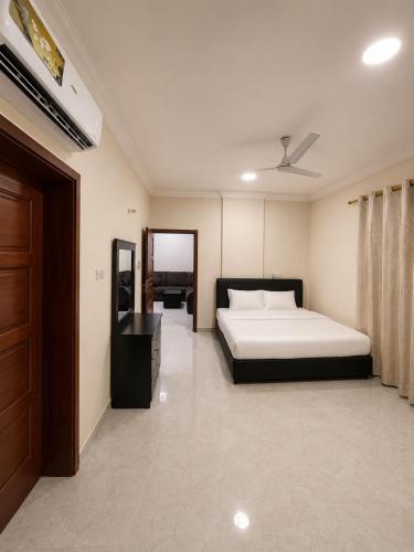 a bedroom with a bed and a dresser in it at RED Bn Saif in Salalah