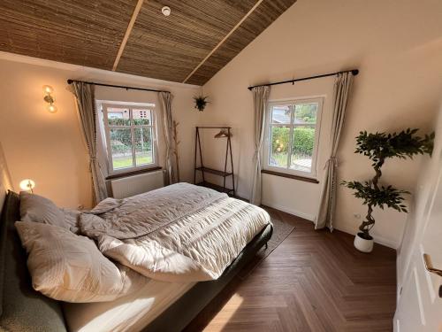 a bedroom with a bed and two windows at Wooden Silence - Wo Ruhe zuhause ist in Soltau