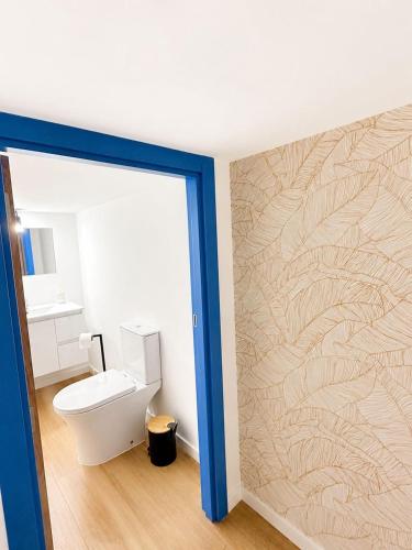 a bathroom with a toilet and a wall at Casa Trainêra in Nazaré
