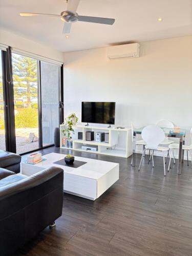 a living room with a couch and a tv at Esperance Waterfront Apartment in Esperance