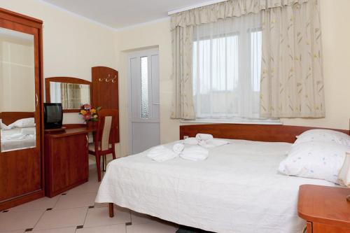 a bedroom with a white bed with towels on it at Dom Gościnny Basia in Niechorze