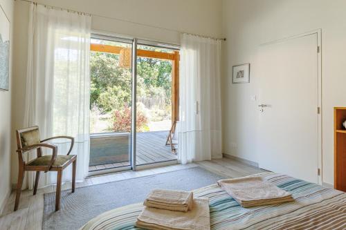 a bedroom with a bed and a sliding glass door at Océan Alegria – Conciergerieland in Léon