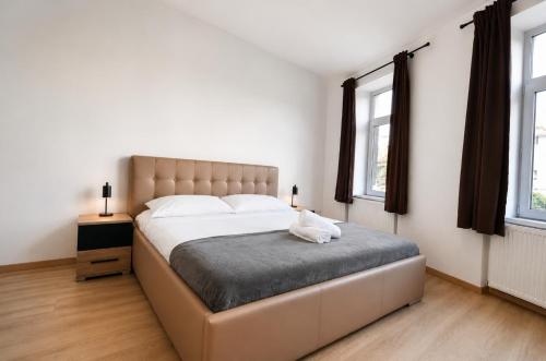 a bedroom with a large bed with a white cat sitting on it at Luxurious & Spacious Residence in the Heart of Brașov in Braşov