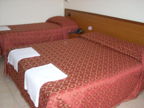 a hotel room with two beds with white towels on them at Hotel Margherita in San Giovanni Rotondo