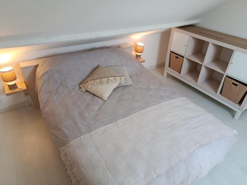 a large bed in a room with two lights at Studio cosy entre terre et mer in Saint-Alban